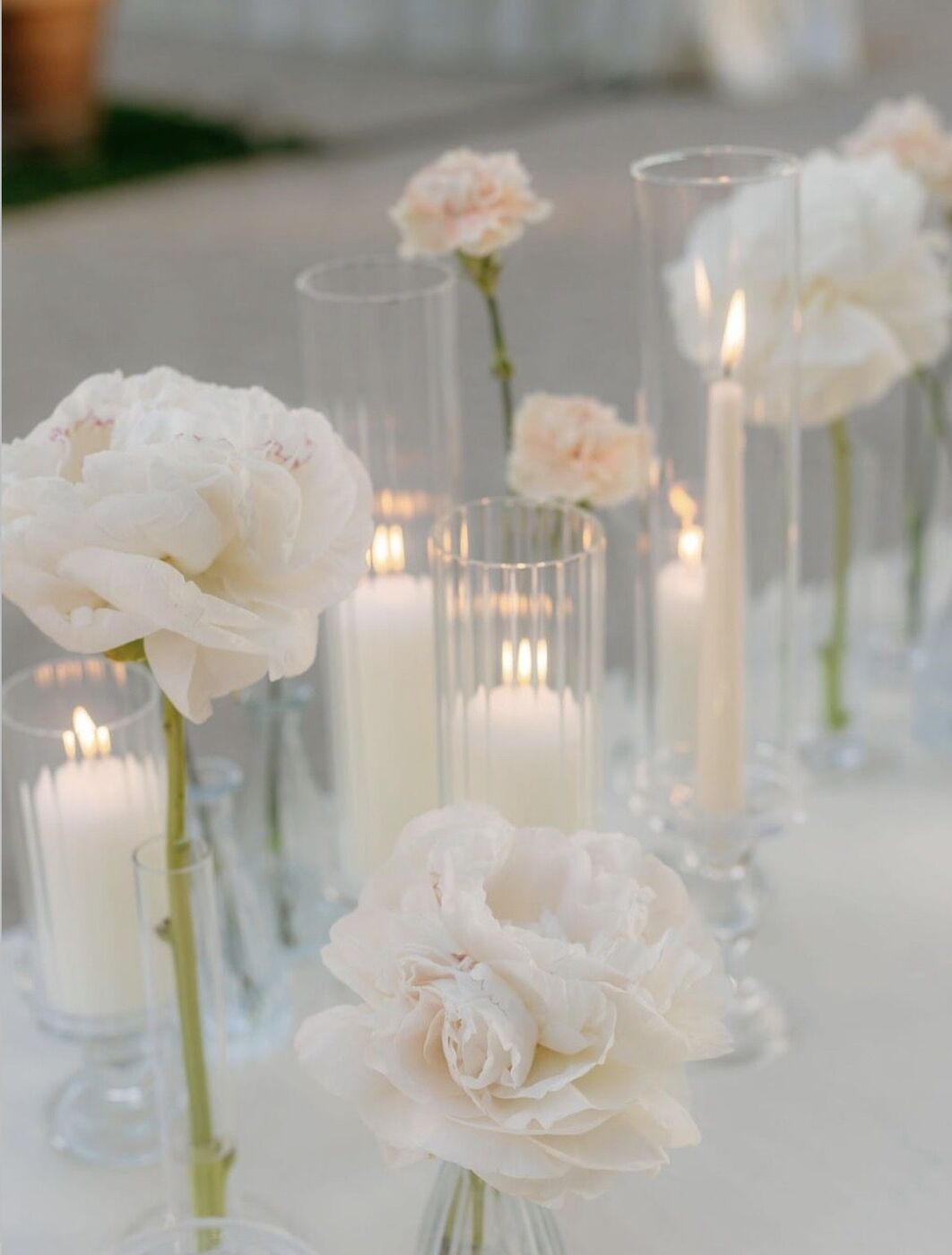 Rose bianche e candele su una tavola apparecchiata