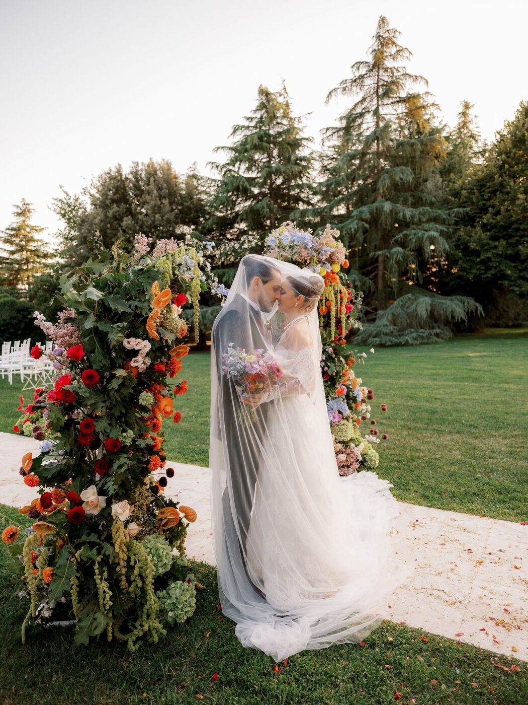 Sposi sotto un arco di fiori rossi e arancioni