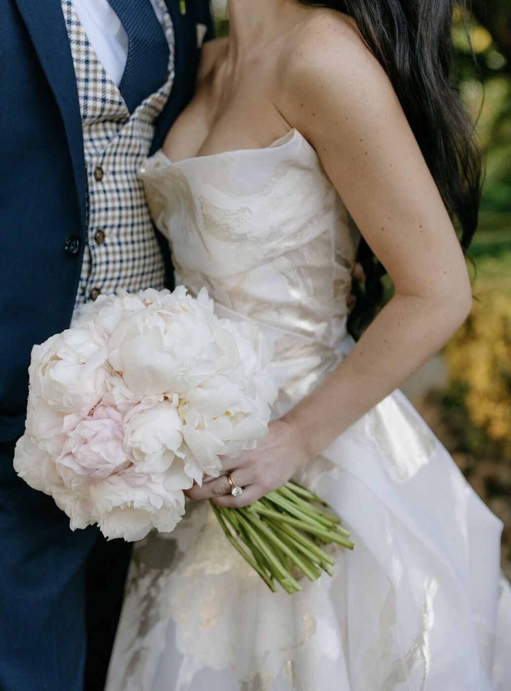 Sposi con un bouquet di peonie bianche