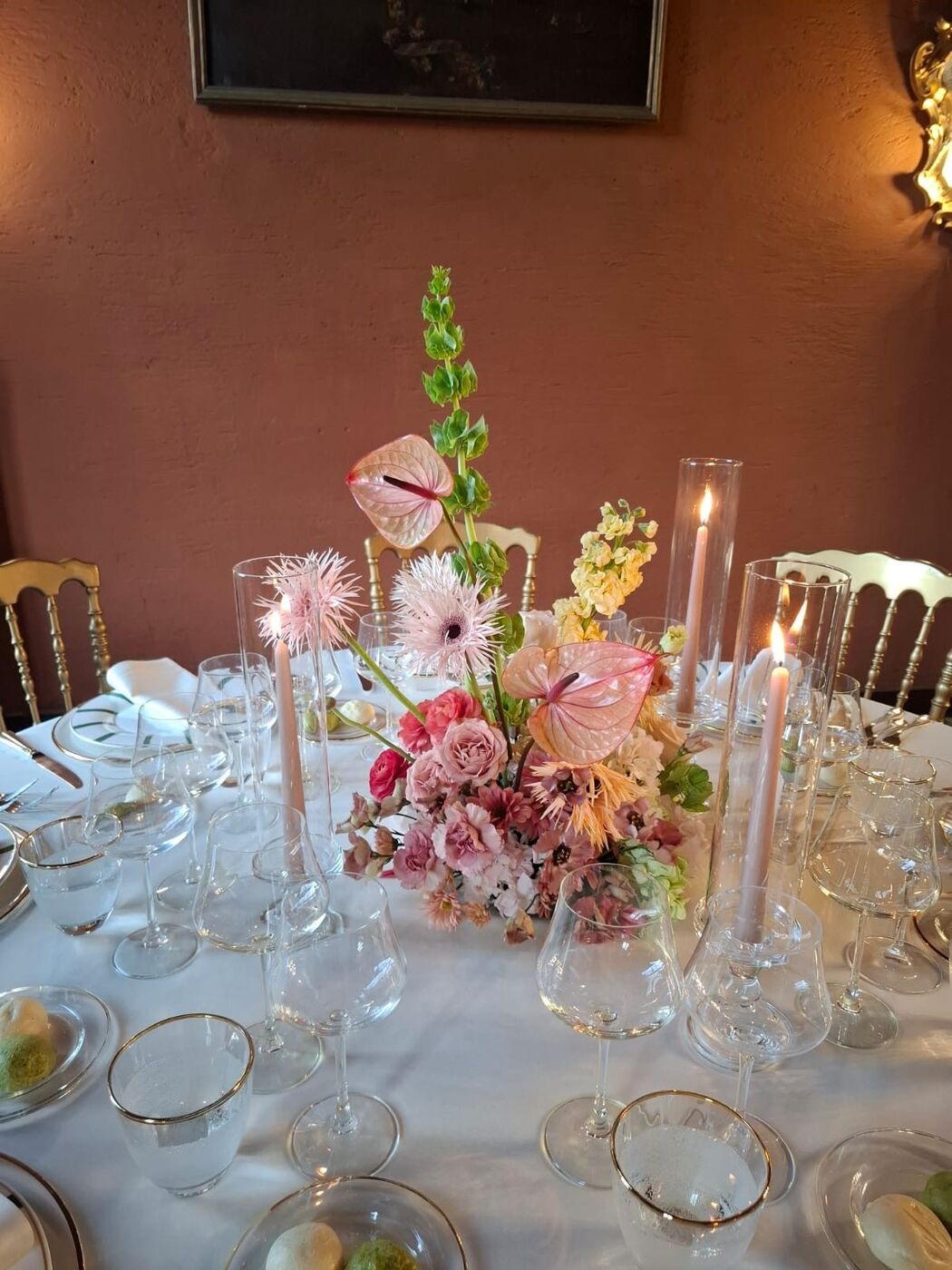 Centrotavola di fiori rosa e candele in una sala rossa
