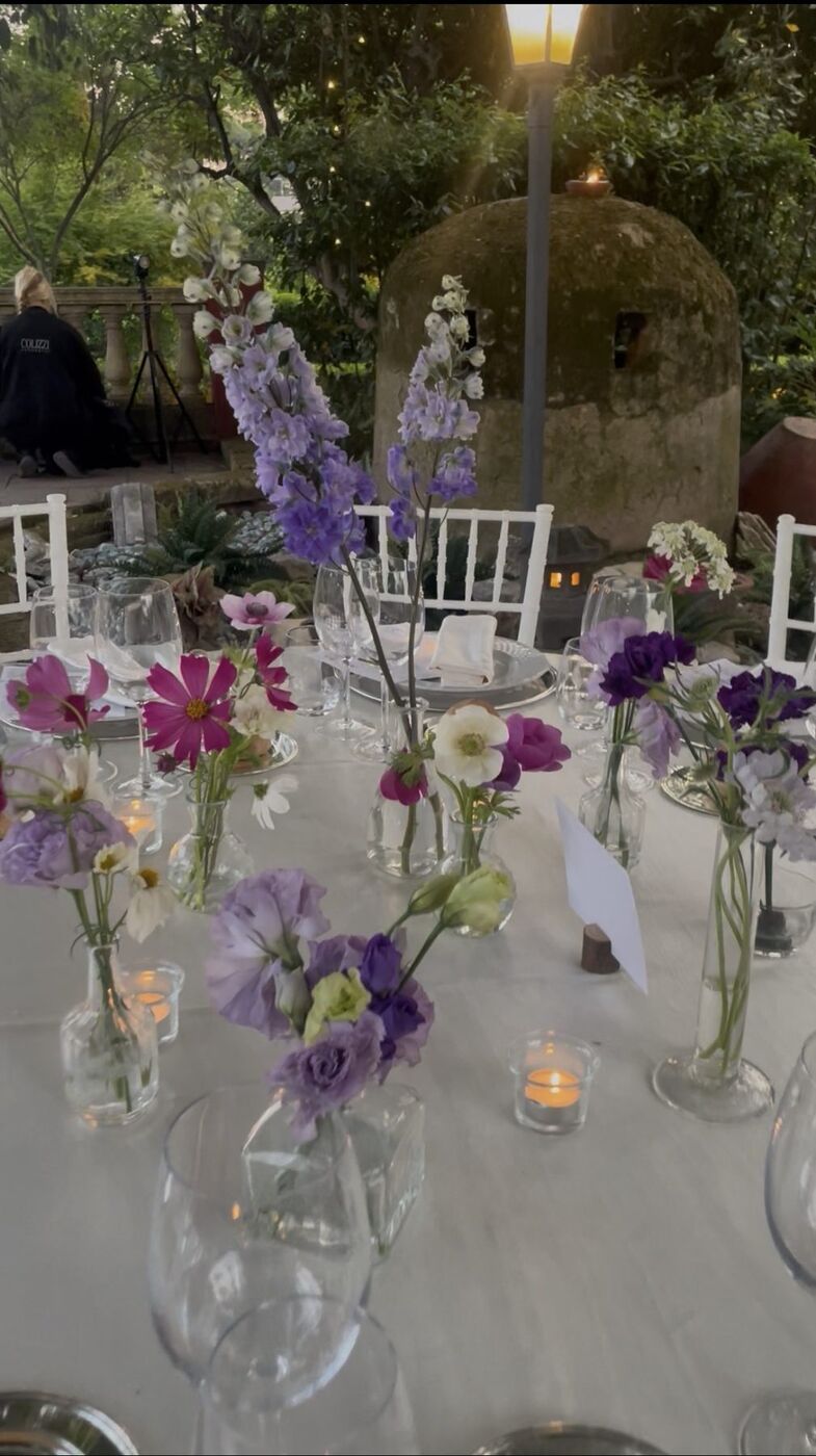 Tavola con piccoli vasi di fiori viola e lilla